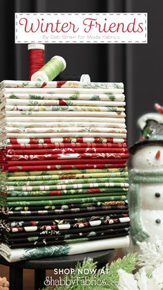 a stack of fabric sitting on top of a table next to a snowman