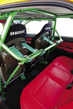 the interior of a small car with red leather seats and green metal bars on it