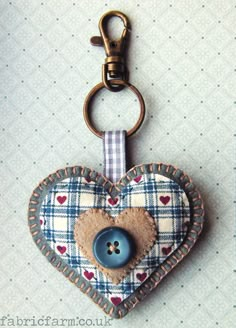 a heart shaped keychain with a button attached to the front and back of it