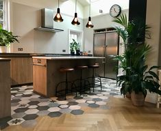 a kitchen with tiled flooring and potted plants on the counter top next to two bar stools