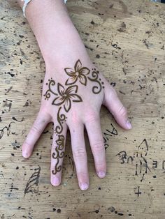 a person's hand with hennap on it and writing on the table