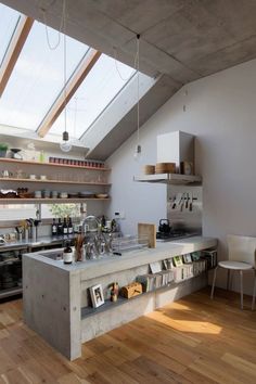 an open kitchen with wooden floors and skylights