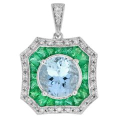 This elegant pendant is centrally set with a sparkly 8 carat aquamarine which is milgrain set. The aquamarine is then surrounded by a target of French cut vibrant green emeralds and glittering diamonds, similarly finished with a milgrain edges. The target hangs from a polished white gold bail. This classic beautiful pendant could be worn for a variety of occasions. Pendant Information Style: Art Deco Metal: 18K White Gold Width: 16 mm. Length: 22 mm. (length excludes chain) Weight: 4.98 g. (appr Emerald Art Deco, Emerald Art, Art Deco Pendant Necklace, Art Deco Metal, Art Deco Pendant, French Cut, Elegant Pendant, Estilo Art Deco, Vibrant Green