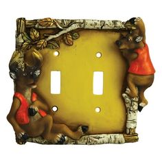 two deers are sitting on the side of a light switch cover