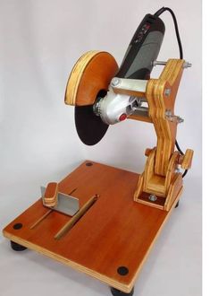 a small wooden machine that is on top of a white surface with an object in the middle