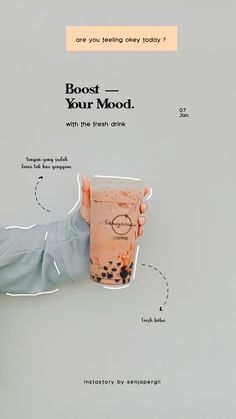 a person holding a drink in their left hand with the words boost your mood on it