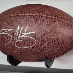 an autographed football sits on a stand