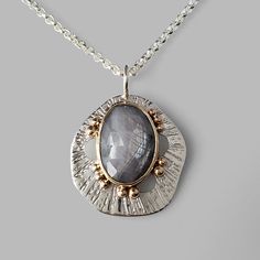 grey sapphire set in yellow gold on textured silver pendant with gold dots Silver Handmade Necklace, Copper And Silver Jewelry, Handmade Jewelry Silver, Handmade Silver Necklace, Silversmith Pendant, Silver Clay Jewelry Ideas, Metal Clay Designs, Handmade Chain Jewelry, Metal Clay Art