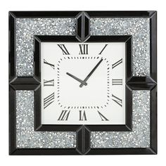 a square clock with roman numerals on the face and black trim around the edges