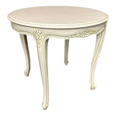 a white table with an ornate design on the top and bottom, against a white background