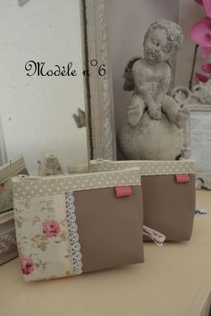 two small purses sitting on top of a table next to a mirror and vase