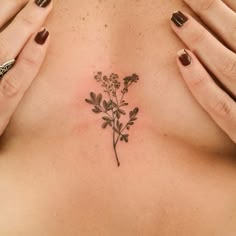 a woman's chest with a small flower tattoo on her left side ribcage