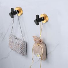 two bags hanging on the wall next to each other, one with a chain attached to it