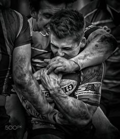 two men hugging each other while playing rugby