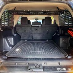 the back end of a vehicle with its cargo area open and luggage in the trunk