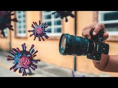 a person holding a camera taking pictures of some corona decorations on the side of a building