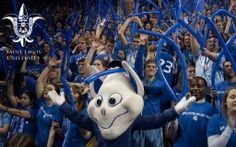 a group of people in blue and white uniforms holding up their hands with one person dressed as an animal