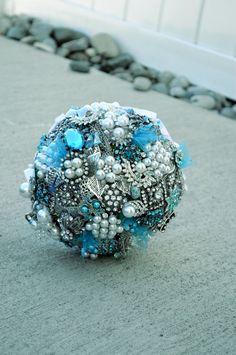 a blue brooch sitting on top of a cement floor next to a white door