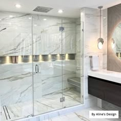 a bathroom with marble walls and flooring in the shower area, along with a large mirror on the wall