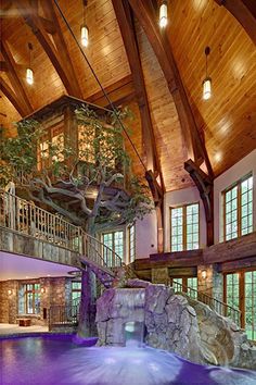 a living room filled with furniture and a tree in the middle of it's ceiling