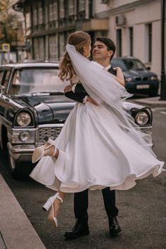 a bride and groom hugging on the street