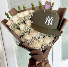 a bouquet of white roses and a yankees hat