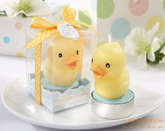 a rubber ducky is sitting in a clear box on a plate with polka dots