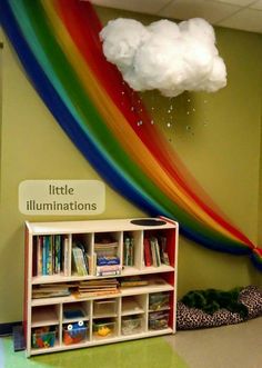 a rainbow wall hanging over a book shelf