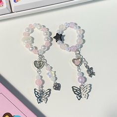 two bracelets with charms on top of a computer keyboard