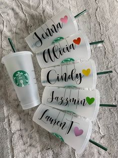 four starbucks cups sitting on top of each other with name tags attached to the cups