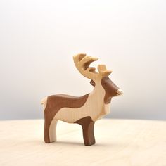 a wooden deer figurine sitting on top of a table