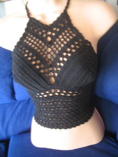 a woman wearing a black top with holes on it's chest and one shoulder