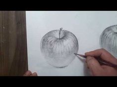 someone is drawing an apple on paper