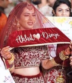 a woman in a red and white bridal gown holding up a sign