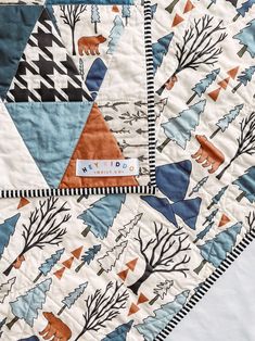 a quilt with trees and animals on it