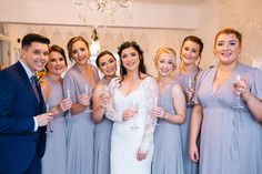 a group of people standing next to each other holding wine glasses