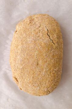 an uncooked loaf of bread sitting on top of a piece of parchment paper