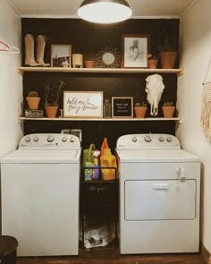 a washer and dryer sitting in a room next to each other with pictures on the wall