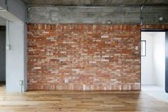 an empty room with brick walls and wooden floors