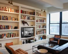 a living room filled with furniture and bookshelves covered in lots of bookcases