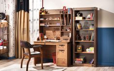 a wooden desk sitting next to a book shelf filled with books on top of a hard wood floor