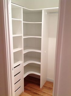 an empty walk in closet with white shelves