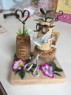 a pair of scissors are sitting on top of some wine corks with flowers growing out of them