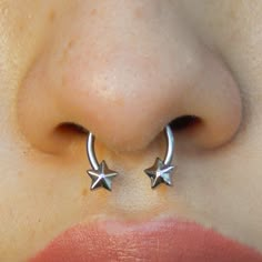 a woman's nose with two silver stars on the side of her nose piercing