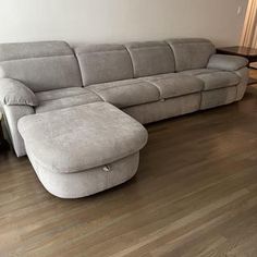 a large sectional couch sitting on top of a hard wood floor