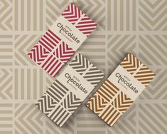 three chocolate bars with different patterns on them sitting side by side in front of a patterned background