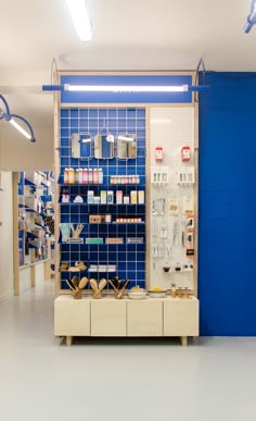 an empty pharmacy room with blue tile walls and shelving in the center, filled with medical supplies