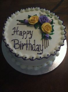 a birthday cake with flowers on it sitting on a table