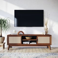 an entertainment center with a large flat screen tv mounted on the wall and two planters next to it