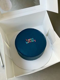 a birthday cake in a white box with the word happy birthday written on it's side